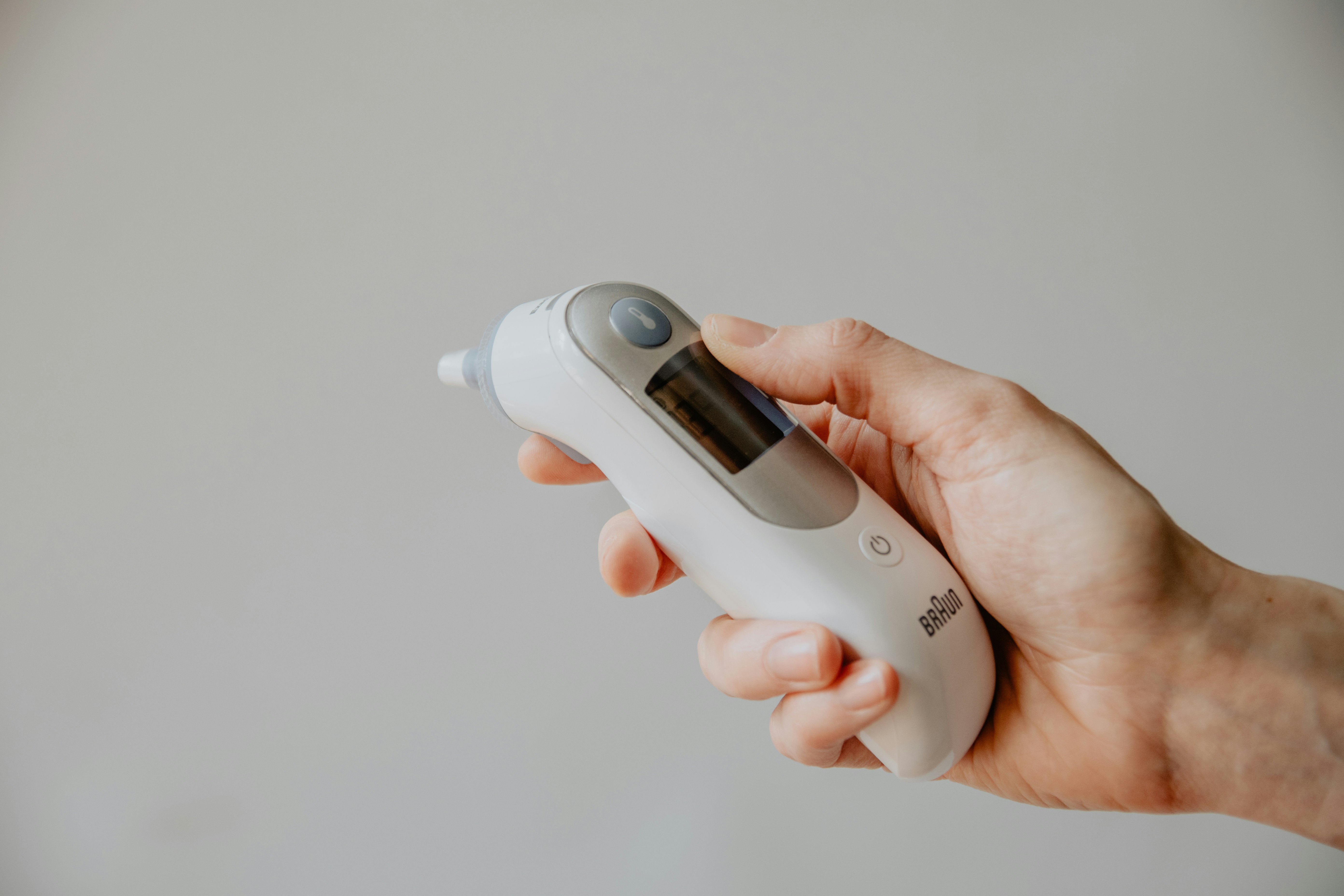 hand holding a thermometer